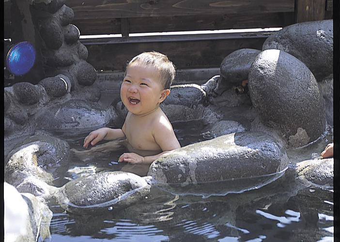 笑顔で温泉に浸かる赤ちゃん