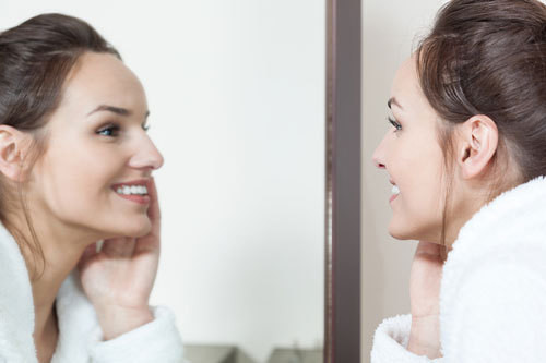 鏡で肌の調子を確認する女性