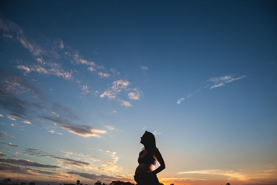 空を見上げる妊婦さんのシルエット